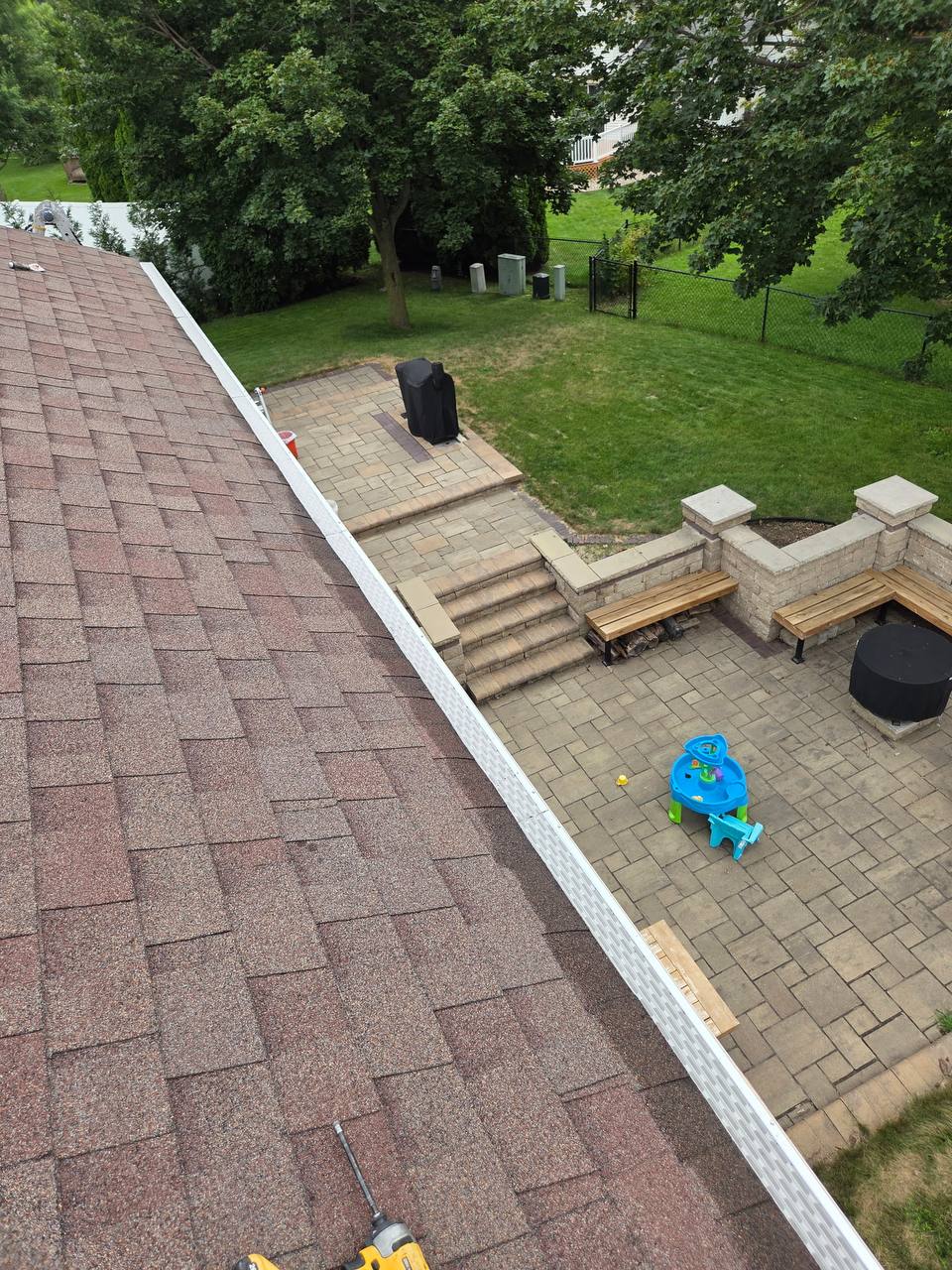 Completed micro-mesh gutter guard run along a shingled roofline