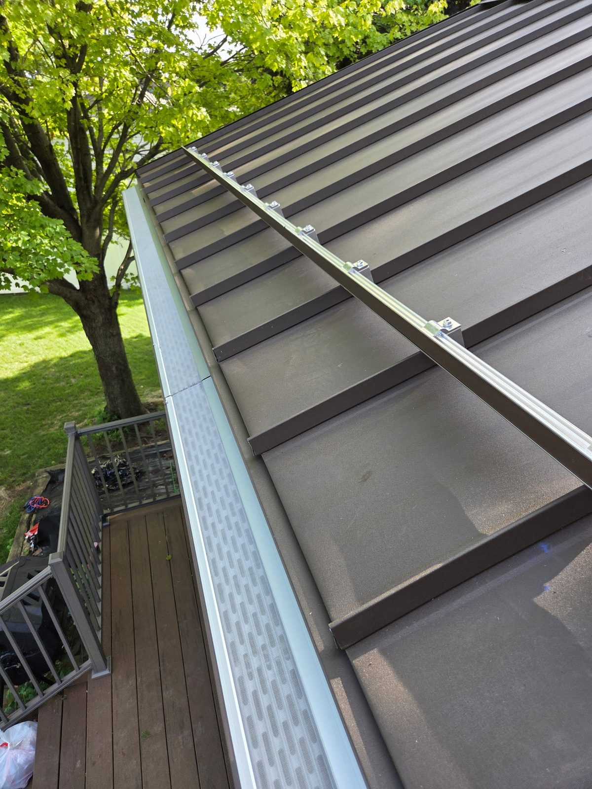 Our micro-mesh guards on a standing-seam metal roof (roof by our metal guy — one network, one house)
