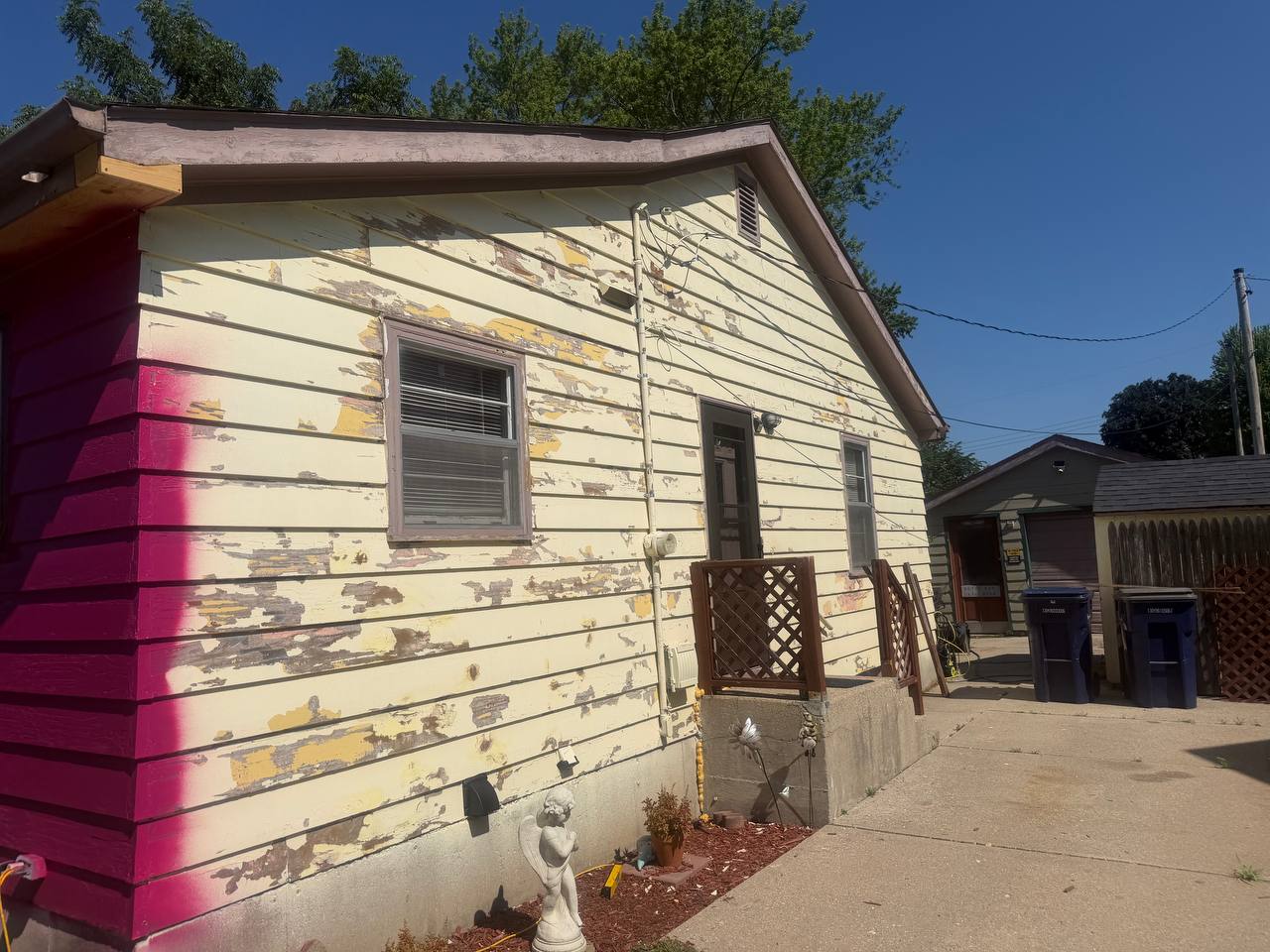 Before: side of the house with worn, weathered siding